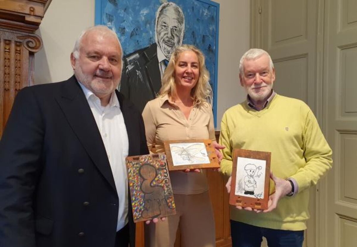 Burgemeester Dedecker, schepen Natacha Lejaeghere en Eric Vandewalle presenteren enkele artistieke dakpannetjes die aangeboden worden op de veiling.