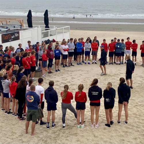 Jongeren luisteren naar briefing op het strand